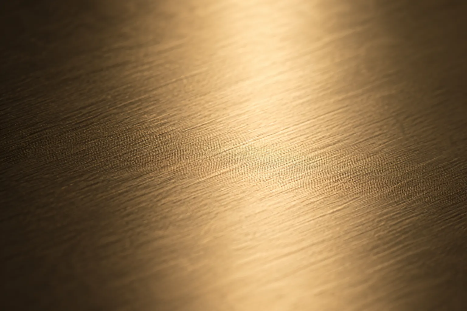 The fine grain of brushed champagne-gold metal